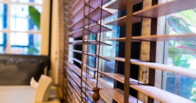 Kobieta wygląda przez okno z żaluzjami