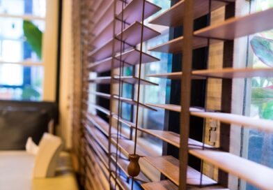 Rolety / Żaluzje Kobieta wygląda przez okno z żaluzjami